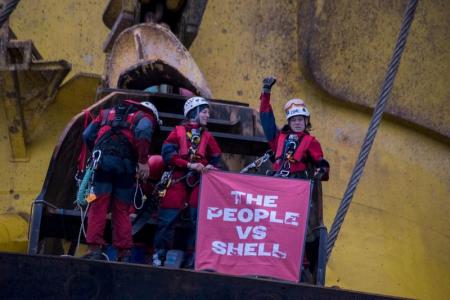 Royal Dutch Shell Plc informó de la presentación de una queja en una corte federal en Alaska, para que sean desalojados los activistas de Greenpeace que treparon el lunes a una plataforma petrolera en el Océano Pacífico que iba camino al Ártico. En la imagen, los activistas muestran una pancarta tras trepar a la Polar Pioneer, transportada por un buque en el Océano Pacífico, el 6 de abril de 2015. REUTERS/Vincenzo Florama/Greenpeace/entregada vía Reuters.