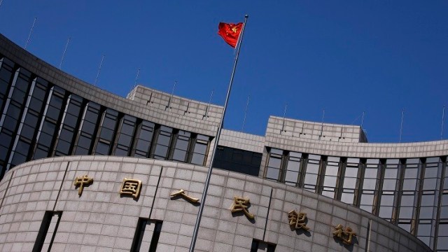 A Chinese national flag flutters outside the headquarters of the People's Bank of China, the Chinese central bank, in Beijing, April 3, 2014. Beijing's attack on yuan speculators has proven extraordinarily successful, so much so that traders no longer see it as a short-term intervention but a deeper market shift that has now gained a self-reinforcing momentum. That's bad news for speculators still holding onto bullish yuan positions. And for the People's Bank of China (PBOC), the risk is it has unleashed bearish forces it may not be able to rein in, souring enthusiasm for the yuan and complicating the push to increase the international adoption of the currency. To match Analysis CHINA-YUAN/    Picture taken April 3, 2014. REUTERS/Petar Kujundzic (CHINA - Tags: BUSINESS) - RTR3NRTO