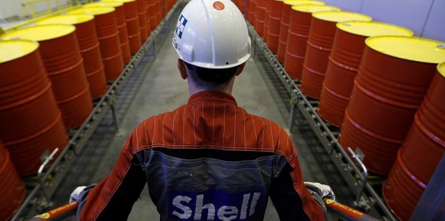 An employee stands in front of lines of oil barrels at Royal Dutch Shell Plc's lubricants blending plant in the town of Torzhok, north-west of Tver, November 7, 2014. Picture taken November 7, 2014. REUTERS/Sergei Karpukhin (RUSSIA - Tags: BUSINESS INDUSTRIAL) - RTR4FWLJ